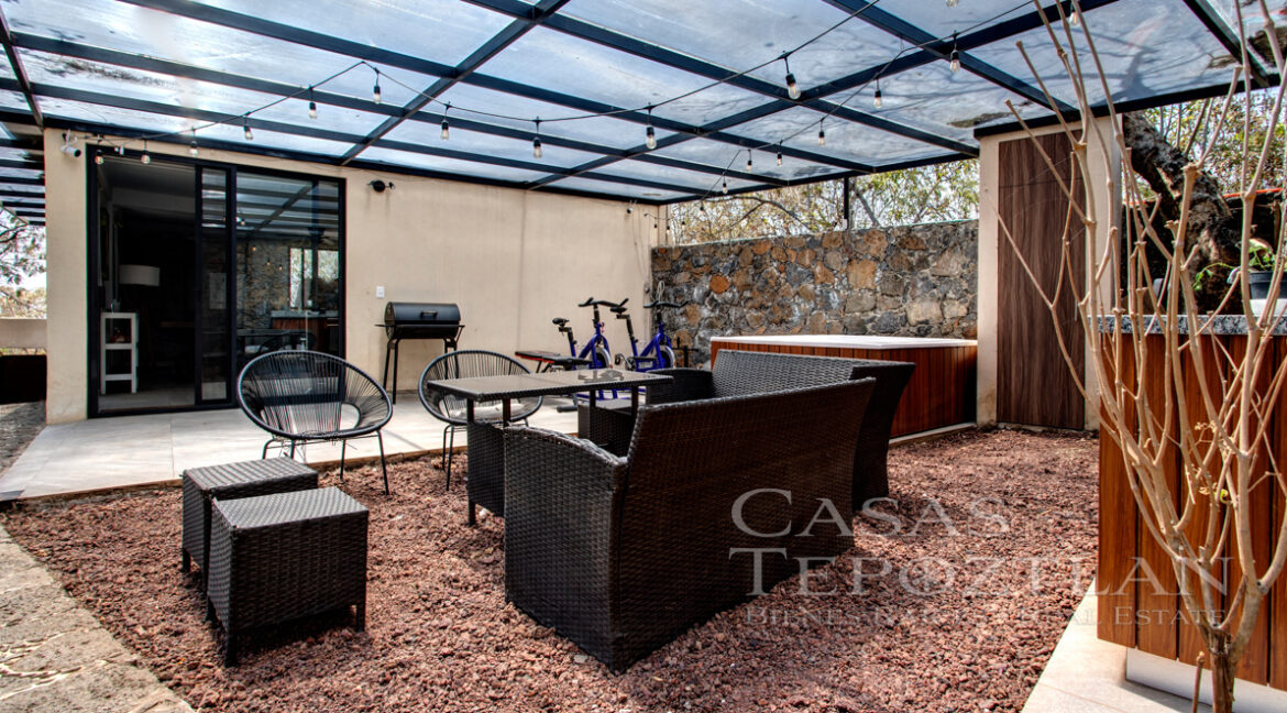 Hermosa_casa_de_piedra_con_gradnes_ventanales_bardeada_privada_con_estacionamiento_para_varios_autos_afuera