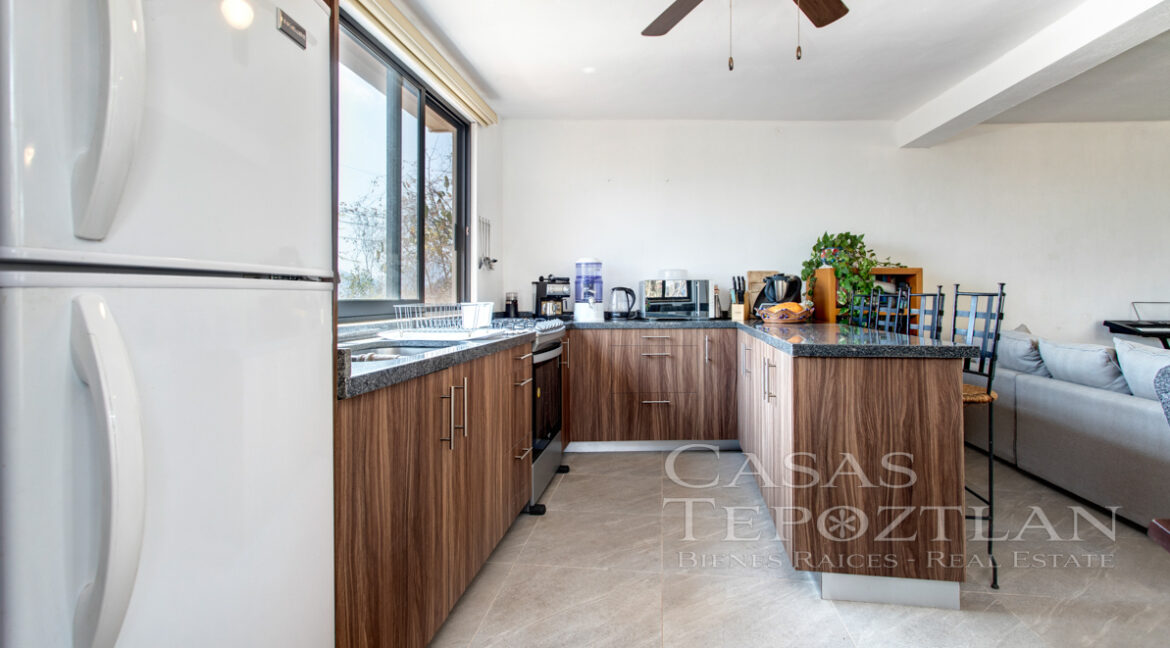 Hermosa_casa_de_piedra_con_gradnes_ventanales_bardeada_privada_con_estacionamiento_para_varios_autos_cocina