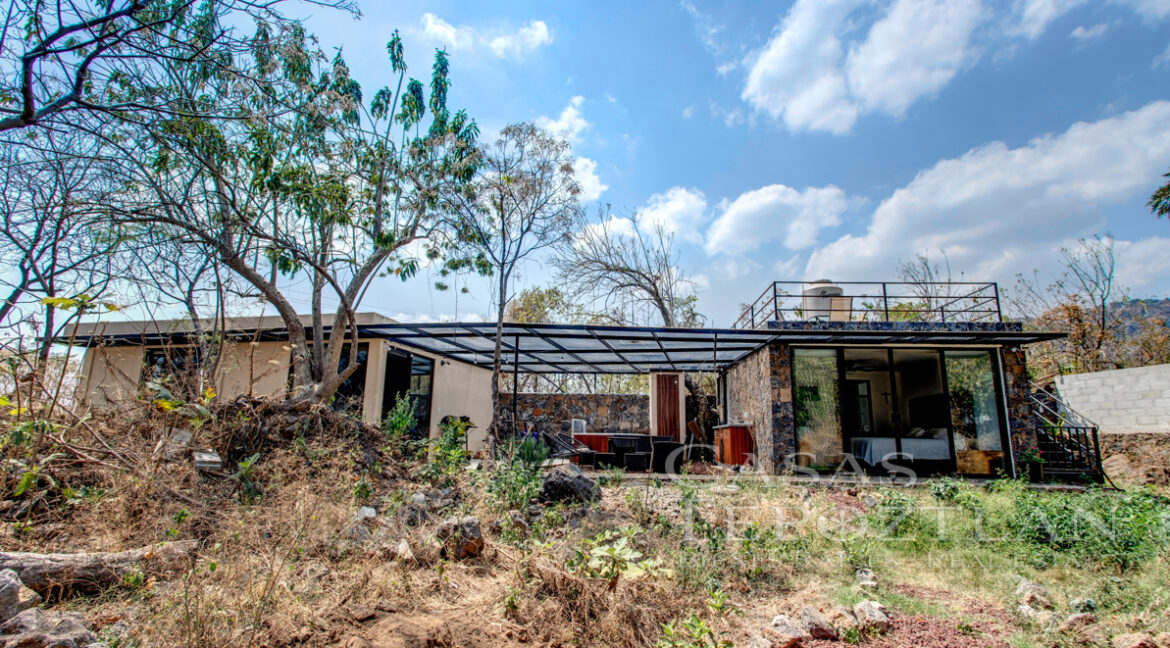Hermosa_casa_de_piedra_con_gradnes_ventanales_bardeada_privada_con_estacionamiento_para_varios_autos_fachada